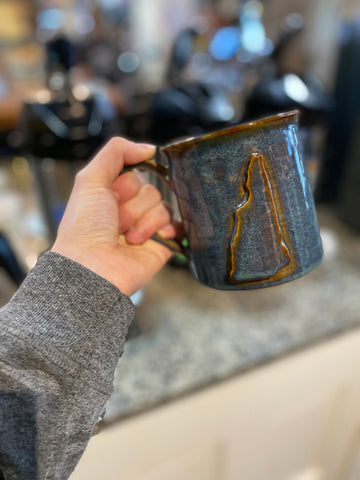 Blue mug held in an outstretched hand 